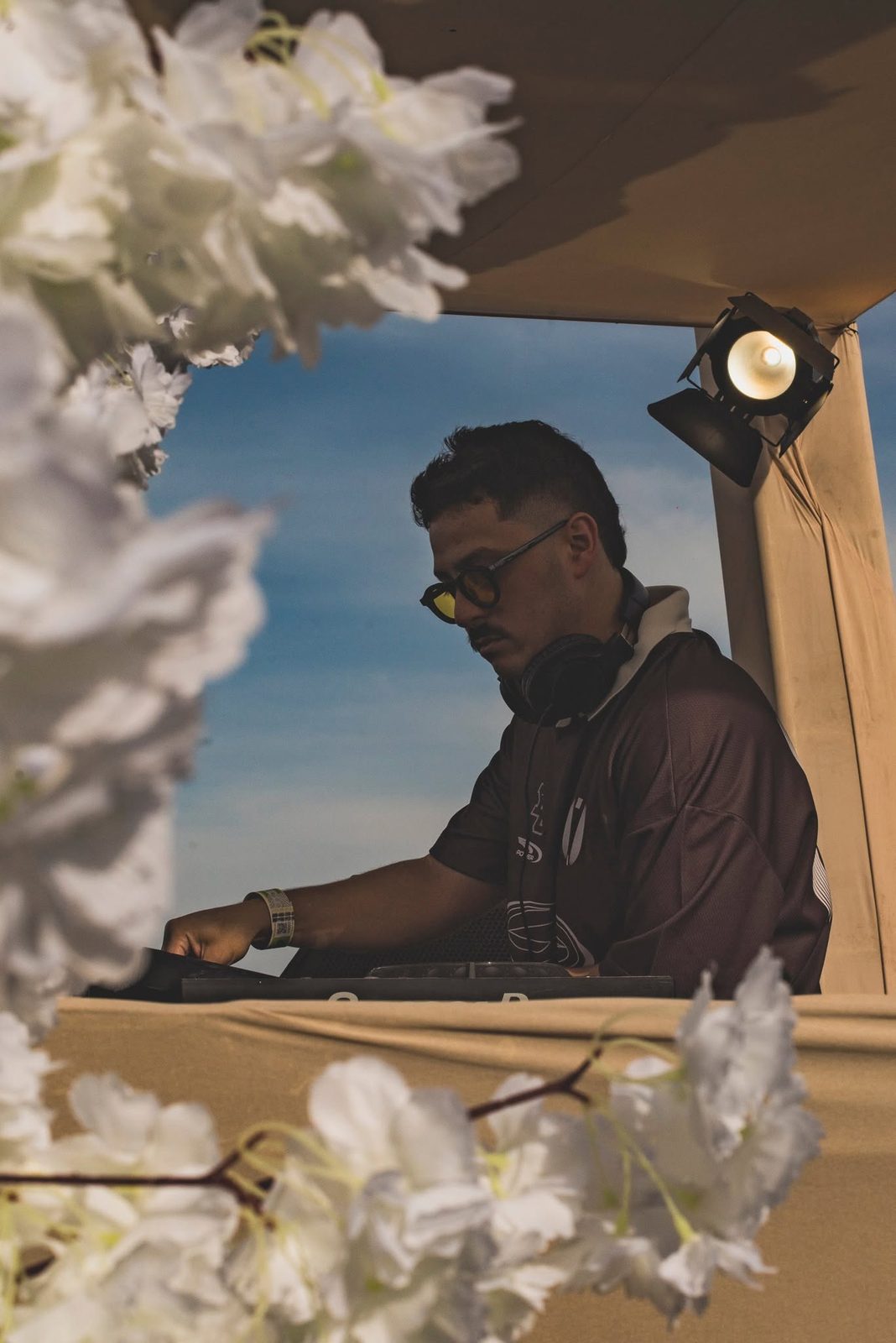 Kevin Disko na cabine do Warung Tour, entre flores brancas